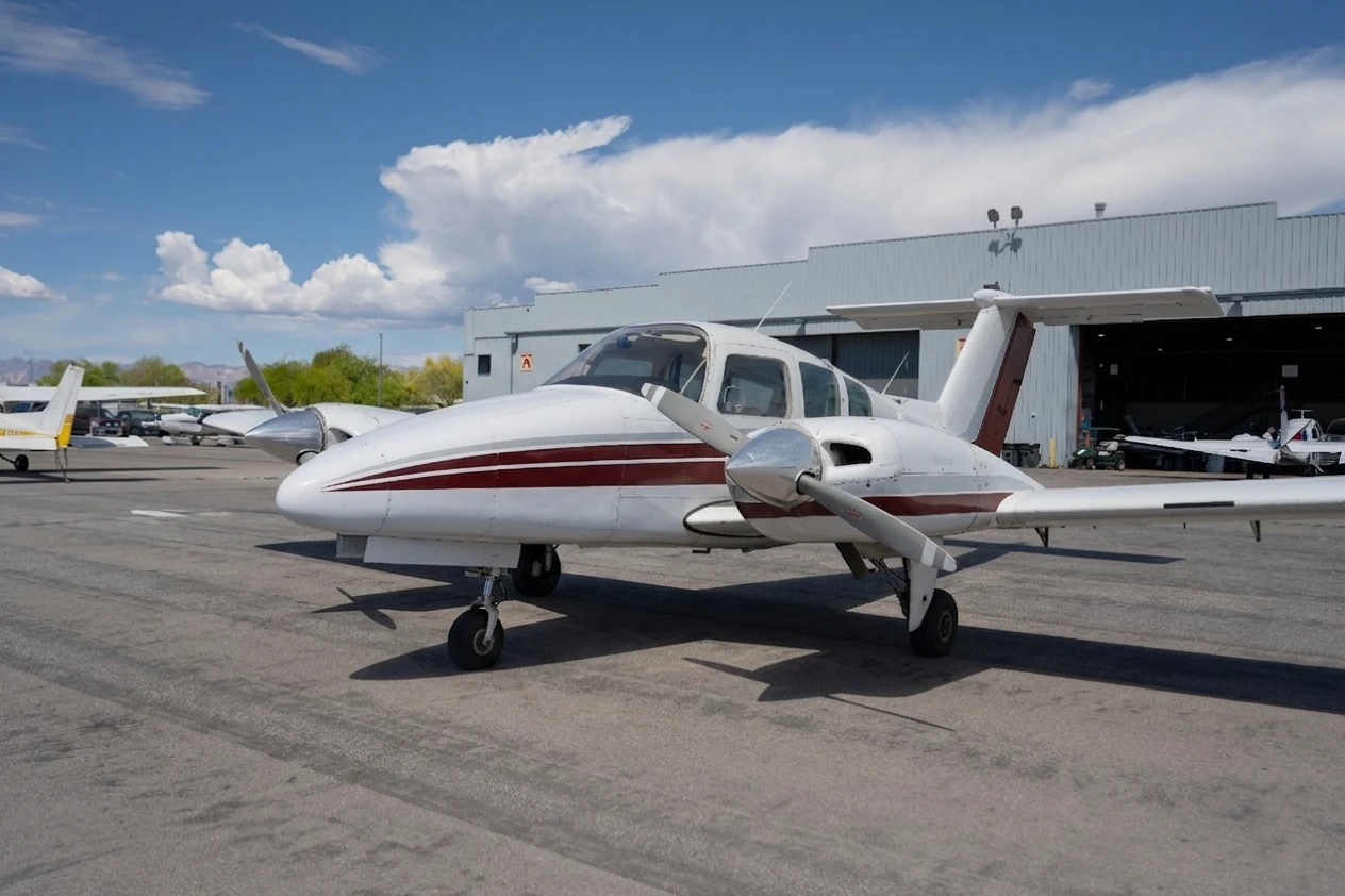 Multi-engine aircraft in front of hangar seen from the front