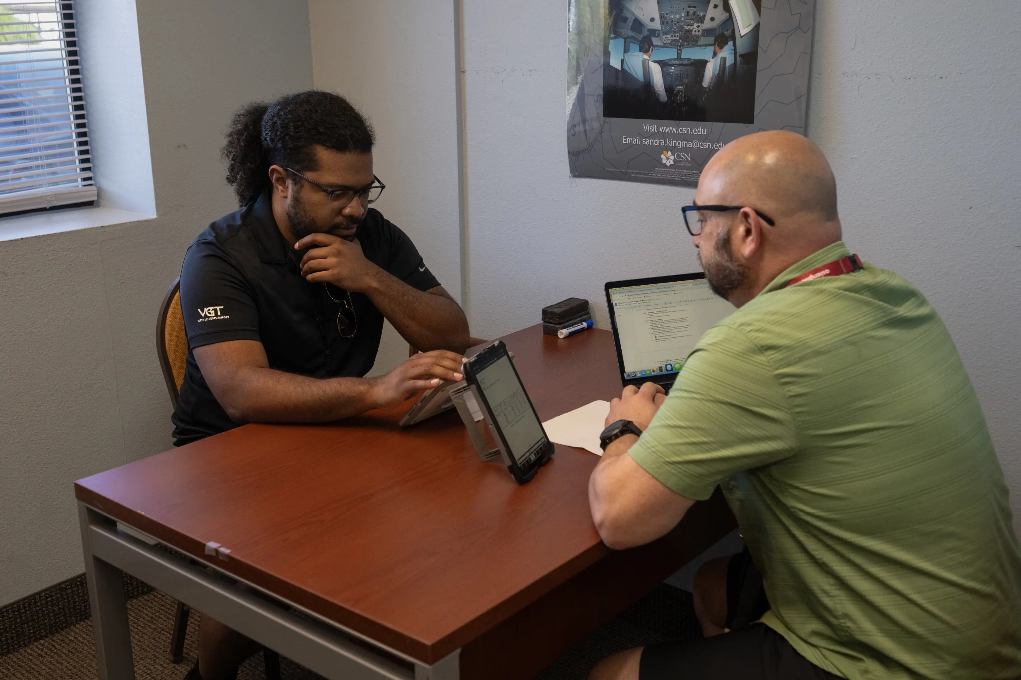 Student and instructor reviewing flight training material indoors