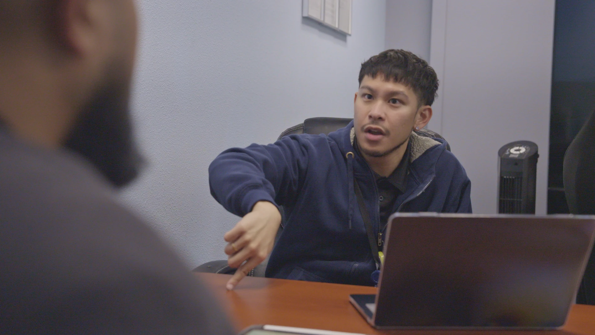Man making explanation inside office with laptop