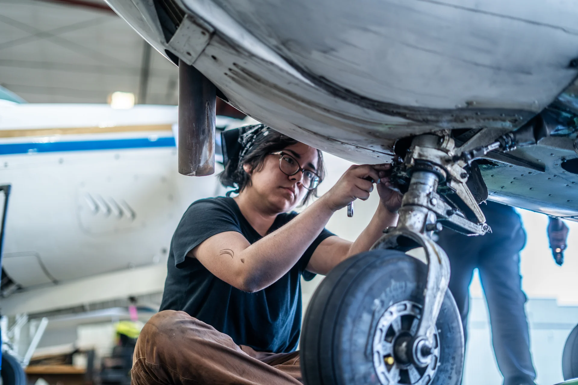 Vegas Aviation mechanic servicing an aircraft landing gear assembly in the hangar