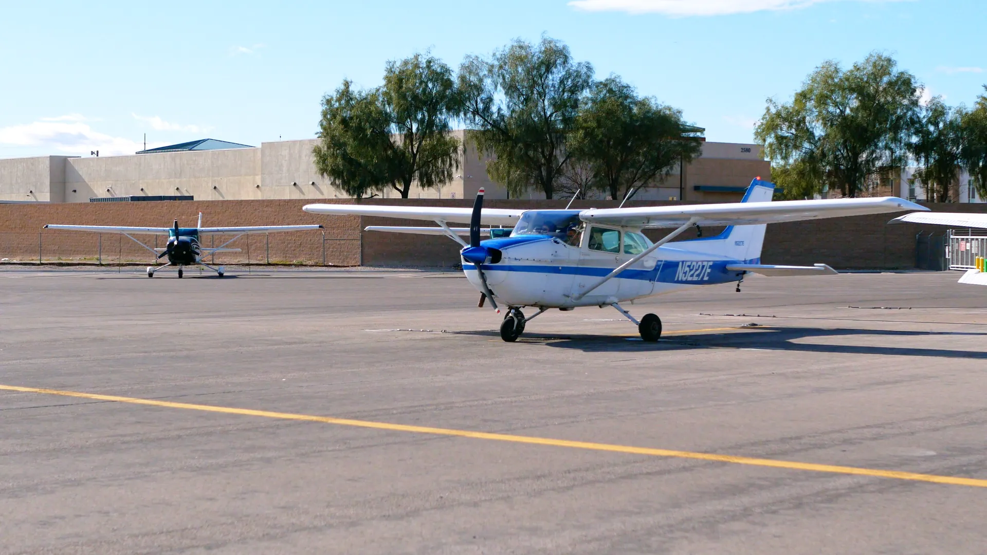 Two training aircraft parked together on the ramp
